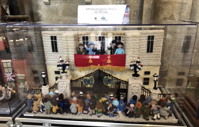 Knitted scene from The Longest Yarn 2. The scene is of Buckingham Palace on VE Day. It shows Buckingham Palace, balcony with the Royal family, the gates with the crowd gathered outside.