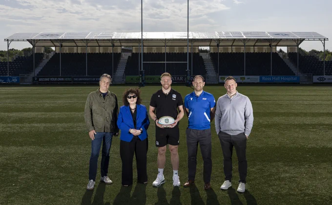 Kyle Steyn at the Glasgow Warriors rugby pitch with representatives from Strathclyde, Denholm and Glasgow Warriors.