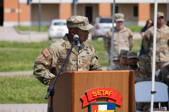 U.S. Army 1st Sgt. Joshua M. Pless Mosley, incoming first sergeant of the Intelligence and Sustainment Company (I&S Co), Headquarters and Headquarters Battalion (HHBn), U.S. Army Southern European Task Force, Africa (SETAF-AF),  speaks from a podium during the change of responsibility ceremony at Caserma Del Din, Vicenza, Italy, June 8, 2026.