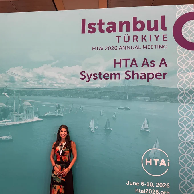 Lilisbeth Perestelo-Pérez junto al cartel del congreso HTAi 2026, celebrado en Estambul desde el 6 hasta el 10 de junio de 2026.