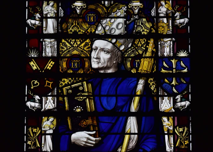Abbot Nicholas Litlyngton depicted in a stained glass window, wearing a mitre and holding a large book