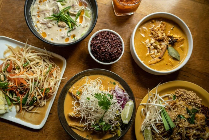 a wooden table topped with plates of food