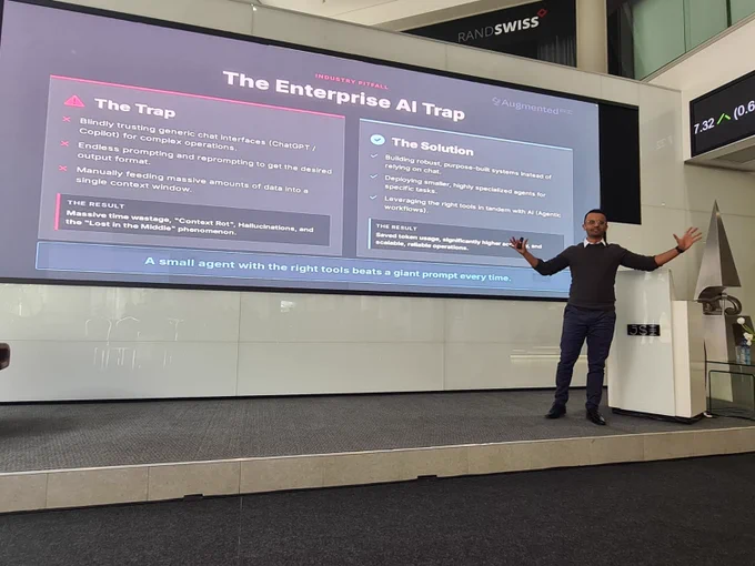 Speaker presenting at the Johannesburg Stock Exchange on Agentic OS and enterprise AI strategy in front of a large screen.