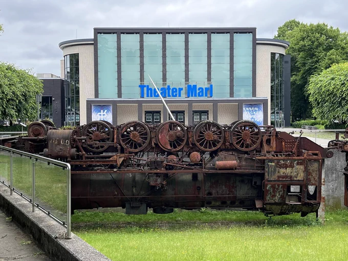 Theater Marl von außen, davor eine alte Maschine aus Metall