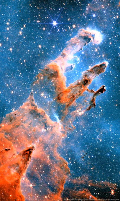 JWST near-infrared image of the Pillars of Creation in the Eagle Nebula (M16): three towering, semi-transparent columns of rust-orange gas and dust rising diagonally across a deep blue starfield densely packed with white and gold stars, several showing JWST's 8-point diffraction spikes. The pillar tips glow and trail wispy structure; dark knots and embedded young stars are visible within and around the columns.