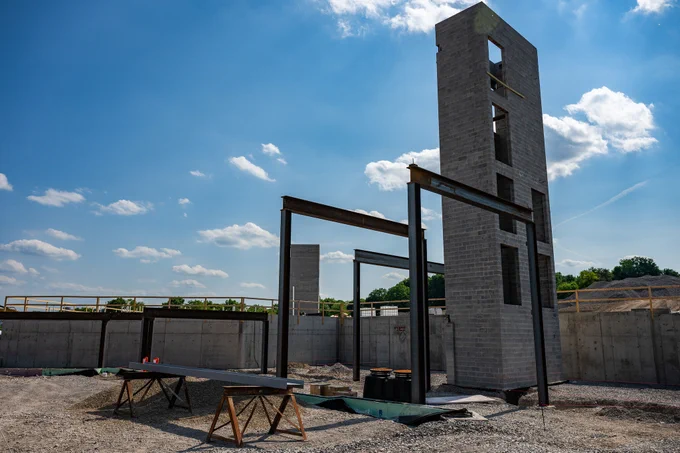 A photo of the current state of the project, there are steel beams in place, and a starwell constructed.