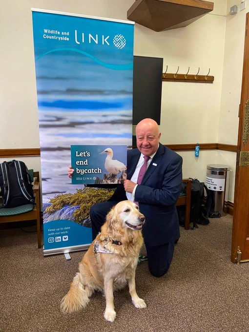 Steve Darling MP holding a sign that reads 'let's end bycatch with a picture of a bird'