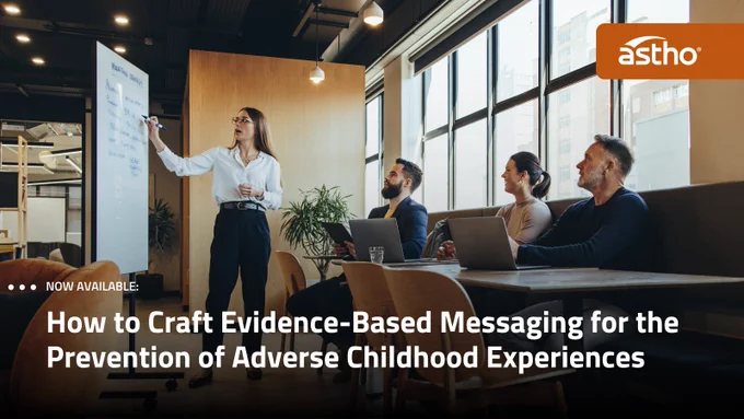 A group of people in a modern meeting room, with one person standing and pointing at a whiteboard. Others are seated with laptops open. The room has large windows and a wooden partition. Text on the image reads, "How to Craft Evidence-Based Messaging for the Prevention of Adverse Childhood Experiences" with "astho" logo in the corner.