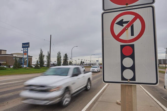 No left turn allowed at this intersection with a red traffic light signal visible on a cloudy day.