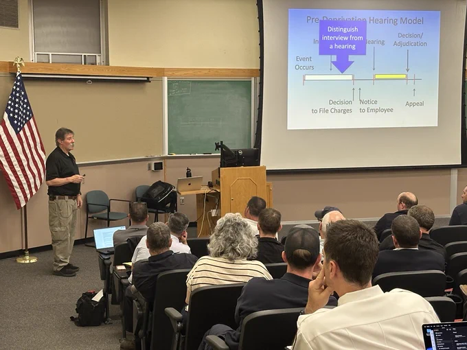 Curt Varone explains the differences between an interview and hearing to a crowd in the Fire Academy auditorium.