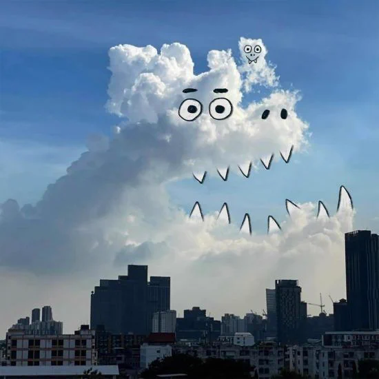 A photograph of a cloud with an overlaid drawing of a monster with sharp teeth. By Chris Judge.