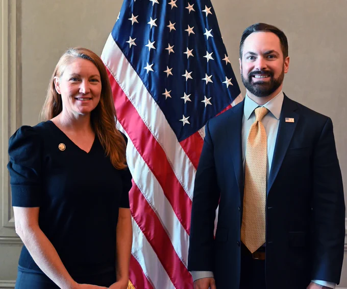 Representative Melanie Stansbury and EPA Regional Administrator Scott Mason standing side by side. Behind them is the U.S. flag.