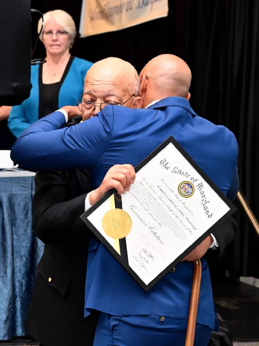 Governor Moore and Warden LaMonte Cook embracing at an event. 