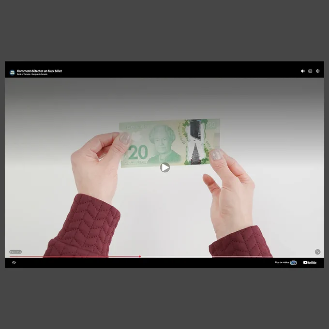 Image vidéo d’une main tenant un billet de banque.