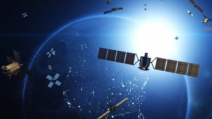 An artistic illustration of multiple satellites orbiting the Earth, with a bright sun shining in the background and city lights visible on the planet's surface.