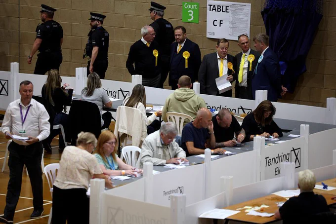 Observers from Britain's Liberal Democrats and Reform UK (L) stand by as ballots are sorted at the Clacton count centre in Clacton-on-Sea, eastern England, on July 4, 2024 as polls close in Britain's general election. 