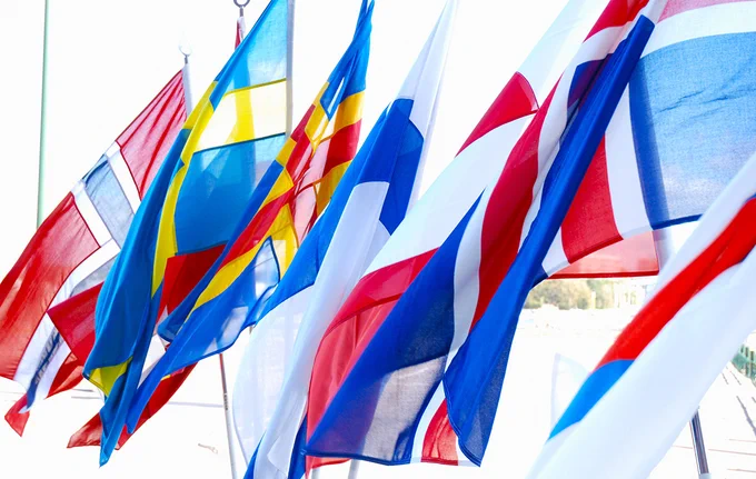 Kuvassa liehuu Pohjoismaiden lippuja ulkona aurinkoisessa säässä. 