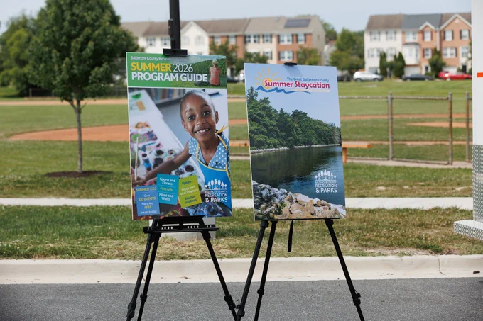 Photo of two signs at the press conference, one advertising the Summer 2026 Program Guide and the other promoting the Rec and Parks "Summer Staycation" initiative.