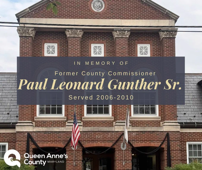 Brick government building with a memorial banner honoring former County Commissioner Paul Leonard Gunther Sr., who served from 2006 to 2010.