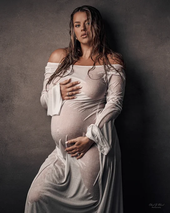 Wet Maternity Shoot: Wet hair and fabric dress clinging to pregnant mother's figure.