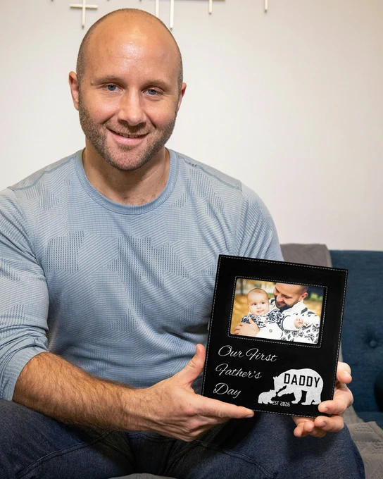 Man Holding Black And Silver Picture Frame With Dad And Baby Photo And Engraved With Bear Art And Fathers Day Message