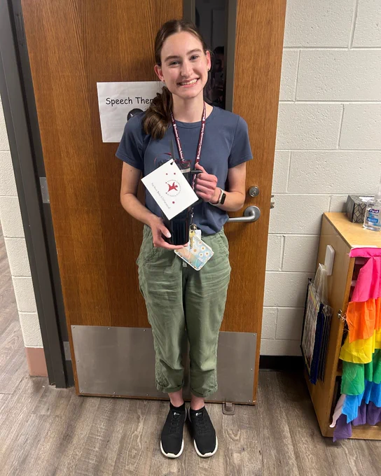 Teacher holds mug and thank you note. 