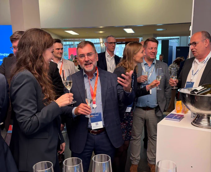 Attendees networking and discussing digital sovereignty following the announcement of the partnership between msg and OpenProject at the Zukunftskongress Staat & Verwaltung 2026.