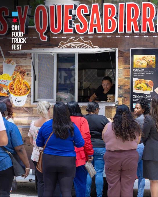 A group of people standing in line at a food truck named "Quesabirria" with "CHI Food Truck Fest" signage. The menu displays images of food items like burritos and veggie tacos. A server is visible inside the truck.