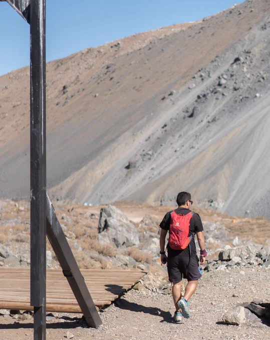Hombre joven con mochila a la espalda haciendo senderismo en la naturaleza.