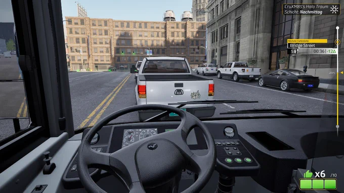 Erste Person Ansicht aus dem Cockpit im Bussimulator Bus Bound. Der Bus wartet an einem sonnigen Nachmittag im dichten Stadtverkehr hinter einem weißen Pickup Truck auf der Straße.