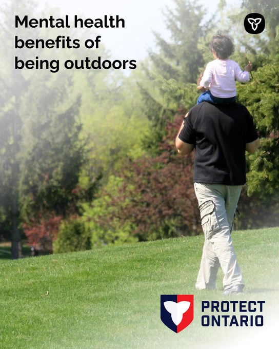 Adult carrying a child on shoulders in a sunlit park; text: mental health benefits of being outdoors