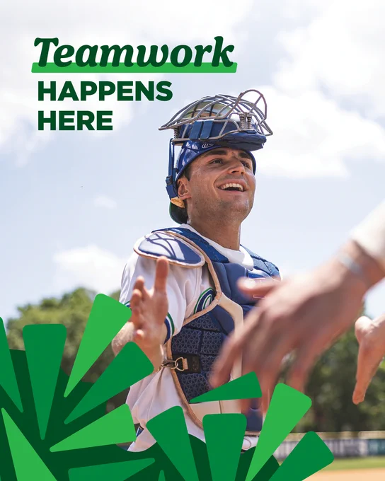 Photo of UWF student-athlete wearing color-white uniform and color-blue protective gear smiling in front of color-blue sky with color-white clouds and color-green trees. Graphics: Color-dark green left bottom-corner graphic with color-green and light green triangles. Text: Teamwork happens here. O. 

