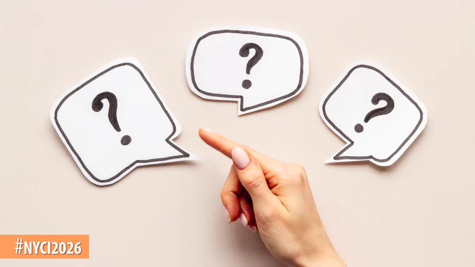 Hand pointing at one of three speech bubbles containing question marks on a beige background, symbolizing inquiry or uncertainty.