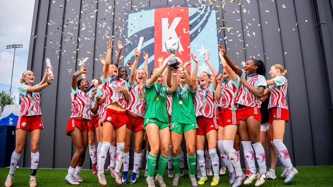 Teal Rising Elite Cup participants celebrating with a trophy raise and confetti after winning the tournament 