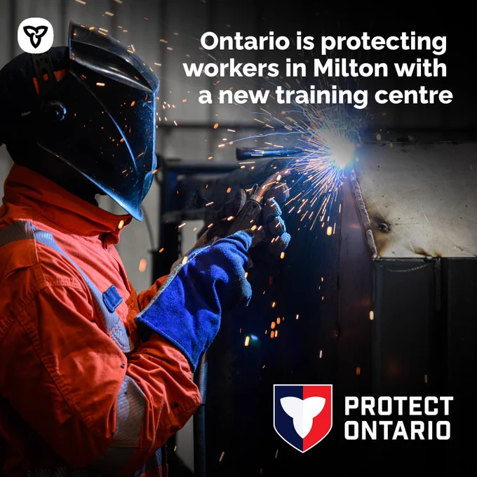 A worker in full protective gear welding metal.