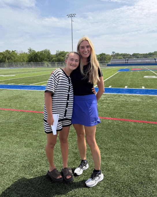 Marita smiling and standing next to Ms. Hager on the football field after receiving her Student of the Year award.