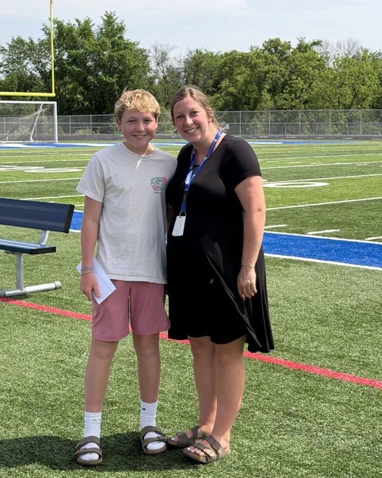 Carter smiling and standing next to Ms. Matter after receiving his Student of the Year award. 