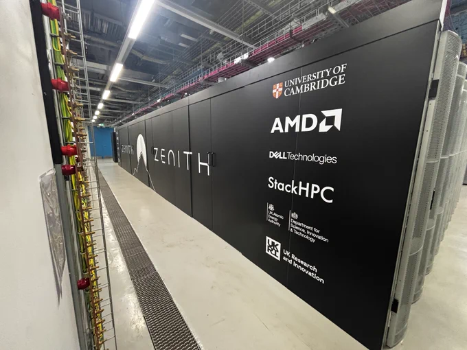 The Zenith AI supercomputer. The sides of the supercomputer display a group of logos. The surroundings include industrial elements like cables and vents.