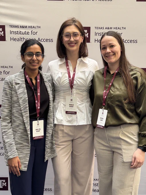 From left to right: Uma Reddy, Natalie Gierat, and Rachel Gano wearing conference badges and standing in front of a Texas A&M Institute for Healthcare Access backdrop.