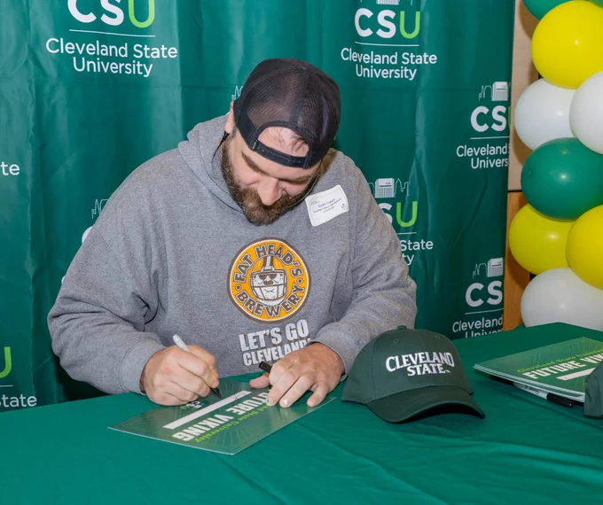 Student signing Future Viking sign in front of CSU backdrop.