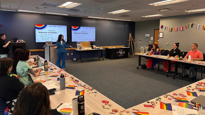 Attorney General Dana Nessel speaking in front of the MI State Police Pride E.R.G. in a conference room. 