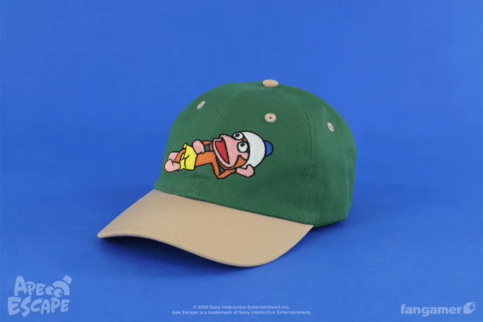 A photo of a forest green cap with a light brown bill. A lounging Pipo Monkey is embroidered across the front. 