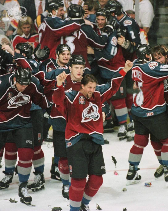 A group of Avalanche players celebrating with rats at their feet after winning the cup