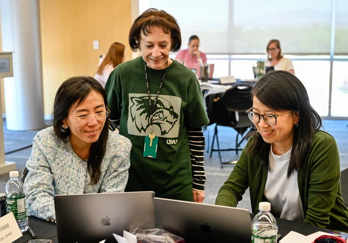 Pam Sua, center, assists two elementary-school teachers prepare materials June 10 to be presented in Chinese-language immersion program.