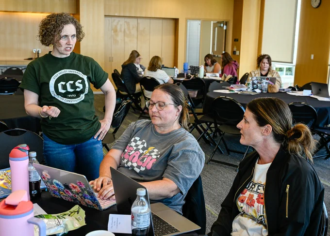 Instructor Tara Chase confers with two teacher attendees at the regional civics training held at Utah Valley University June 10.