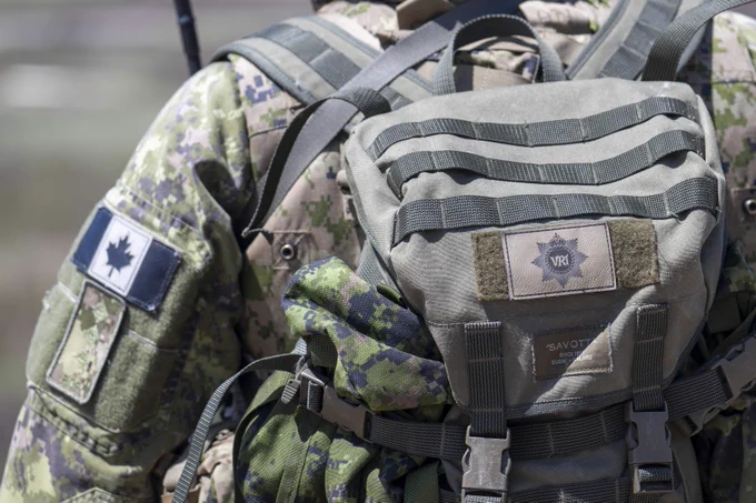 Close-up of a soldier wearing Canadian digital camouflage with a tactical backpack featuring a VRI insignia patch. 