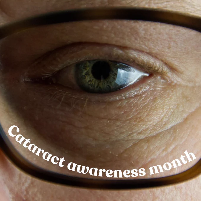 Close up of a persons green eye wearing glasses with text saying cataract awareness month