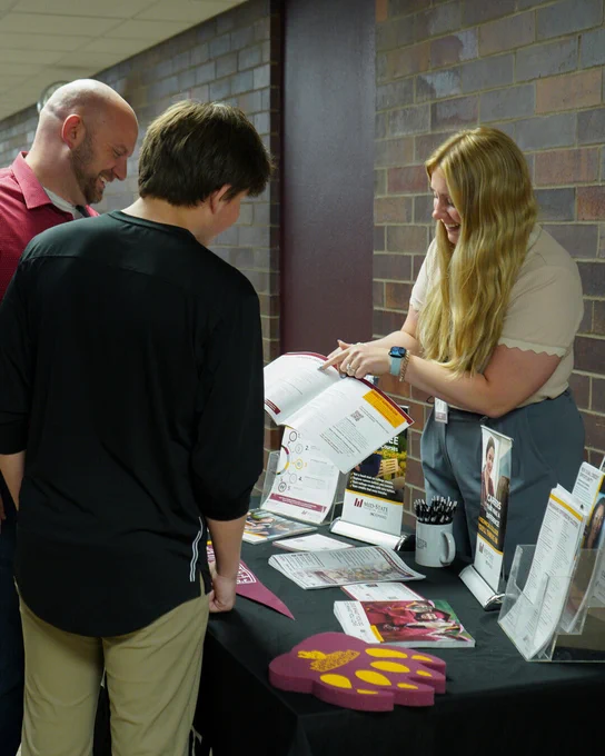 Mid-State outreach member shares program information with prospective learners at a campus resource table.