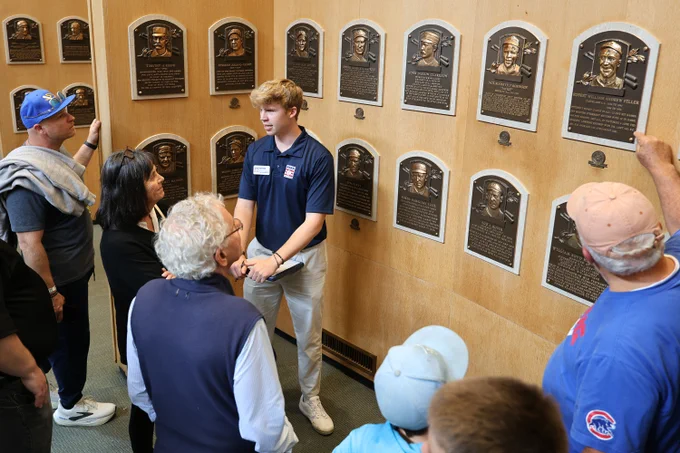A Museum guide leads The Plaques of the Gallery tour for a group of visitors.