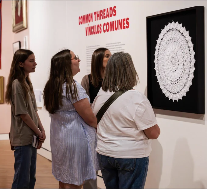 Viewers admire textile work at Crystal Bridges.